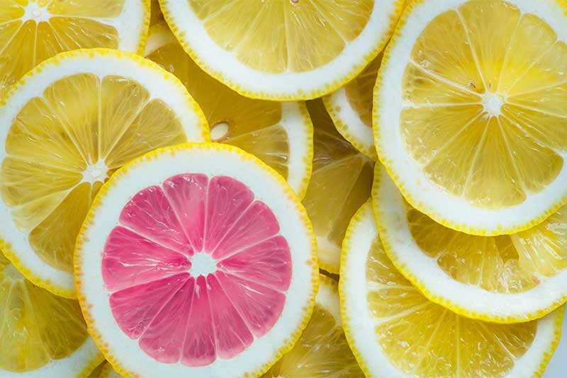 Uno spicchio di limone rosso in mezzo agli spicchi gialli.Specchio del concetto di originalità